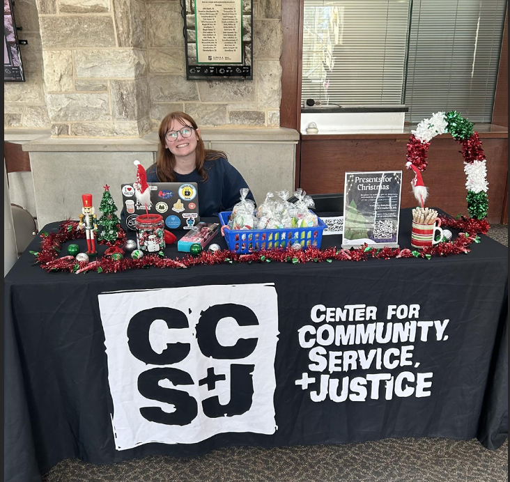 CCSJ intern Emma Hester tabling outside Boulder to raise donations for Presents for Christmas. When you donate, you receive a goody bag and some treats from CCSJ.